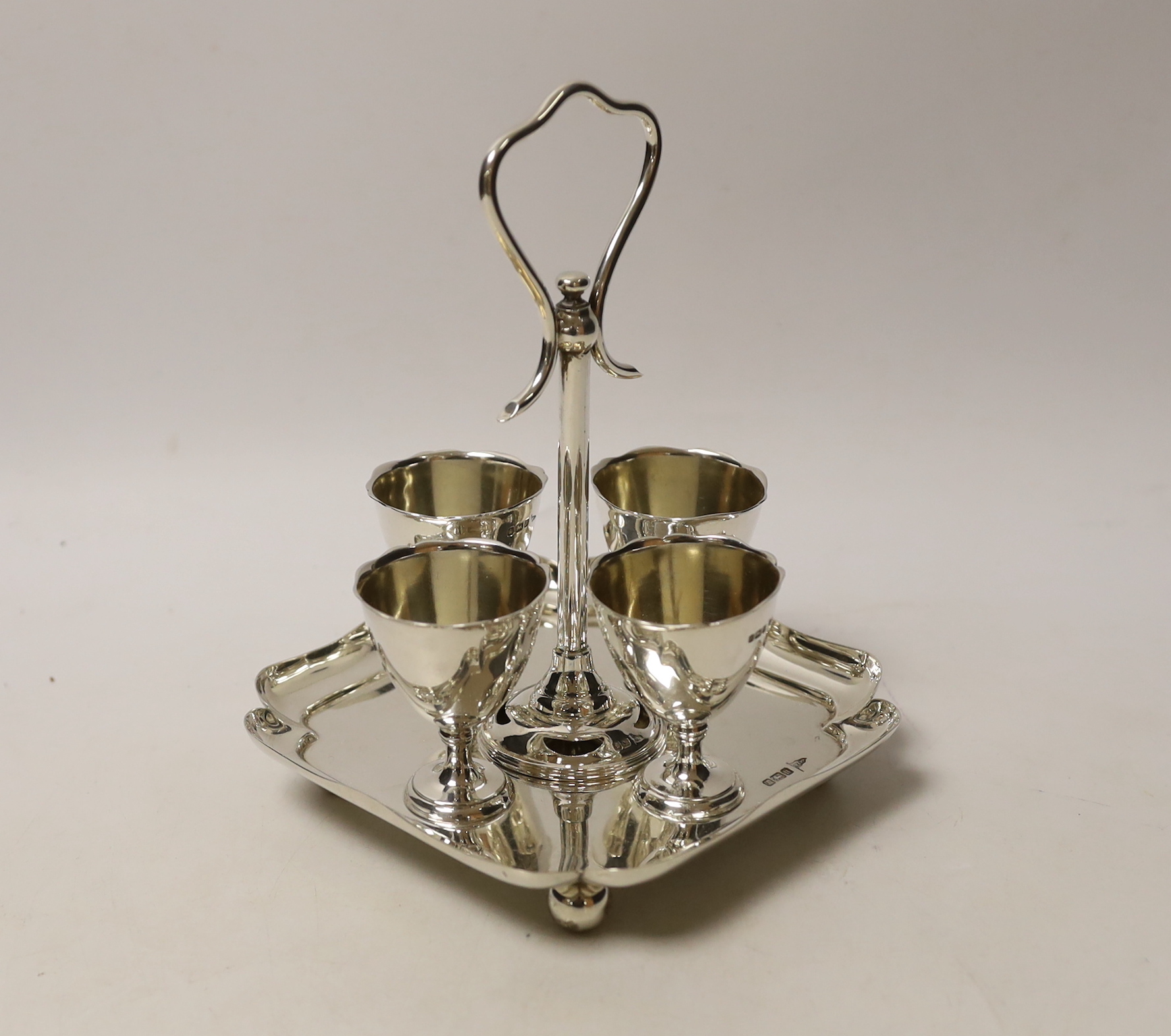 An Edwardian silver egg cruet, with loop handle and four cups, Walker & Hall, Sheffield, 1905/6, height 19.3cm, 17.2oz.